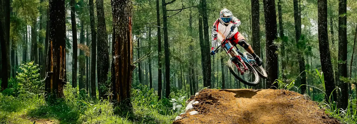 Mountain biker jumping a dirt ramp and performing a trick